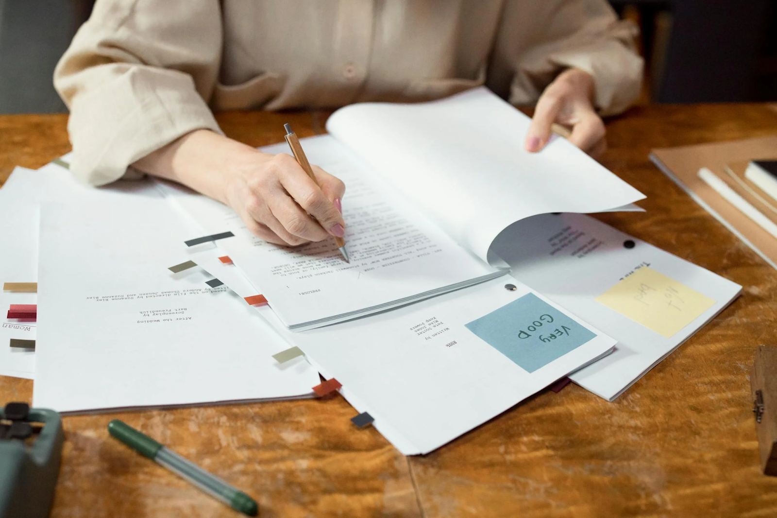 Professor reviewing multiple student assignments on paper, highlighting the manual workload in traditional teaching before adopting simulation based learning.
